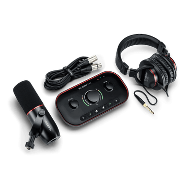 Focusrite Vocaster Two podcast audio interface with microphone and headphones set, studio knolling layout.